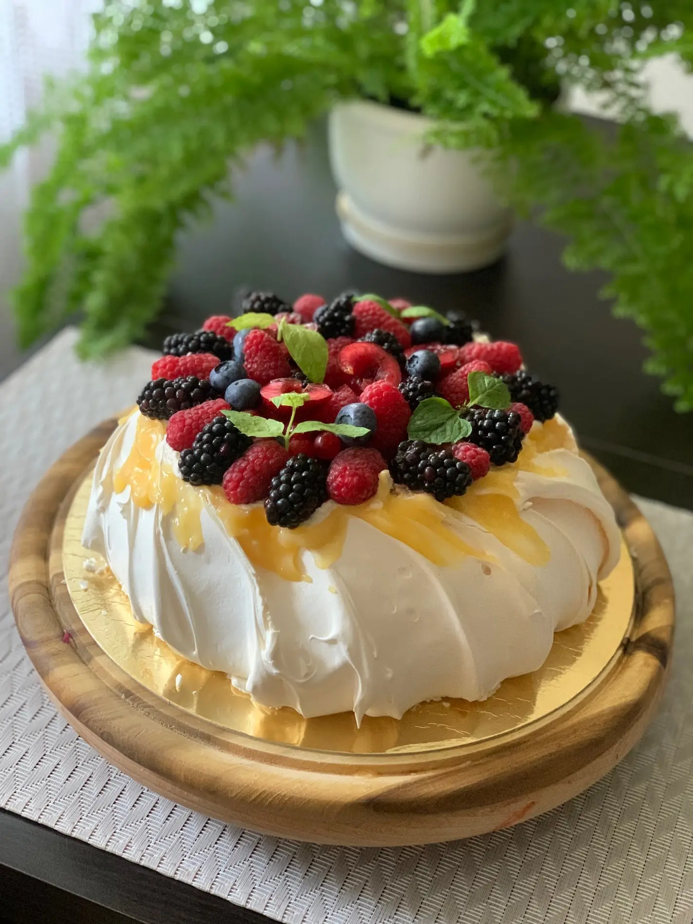 Tort owocowy pavlova z bezą, malinami, jeżynami, jagodami i miętą